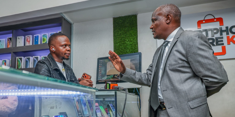 CS John Mbadi speaks with a smartphone dealer during a public participation exercise in Nairobi CBD.